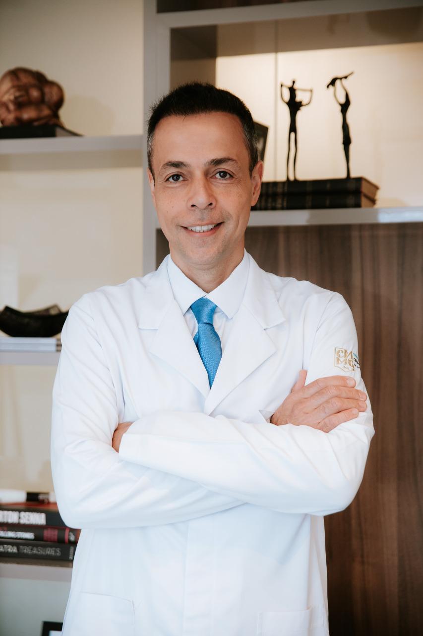 Retrato profissional do Dr. Wilson em jaleco branco, em consultório